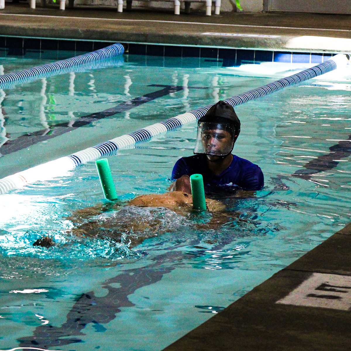 Instructor helping student kick on his back