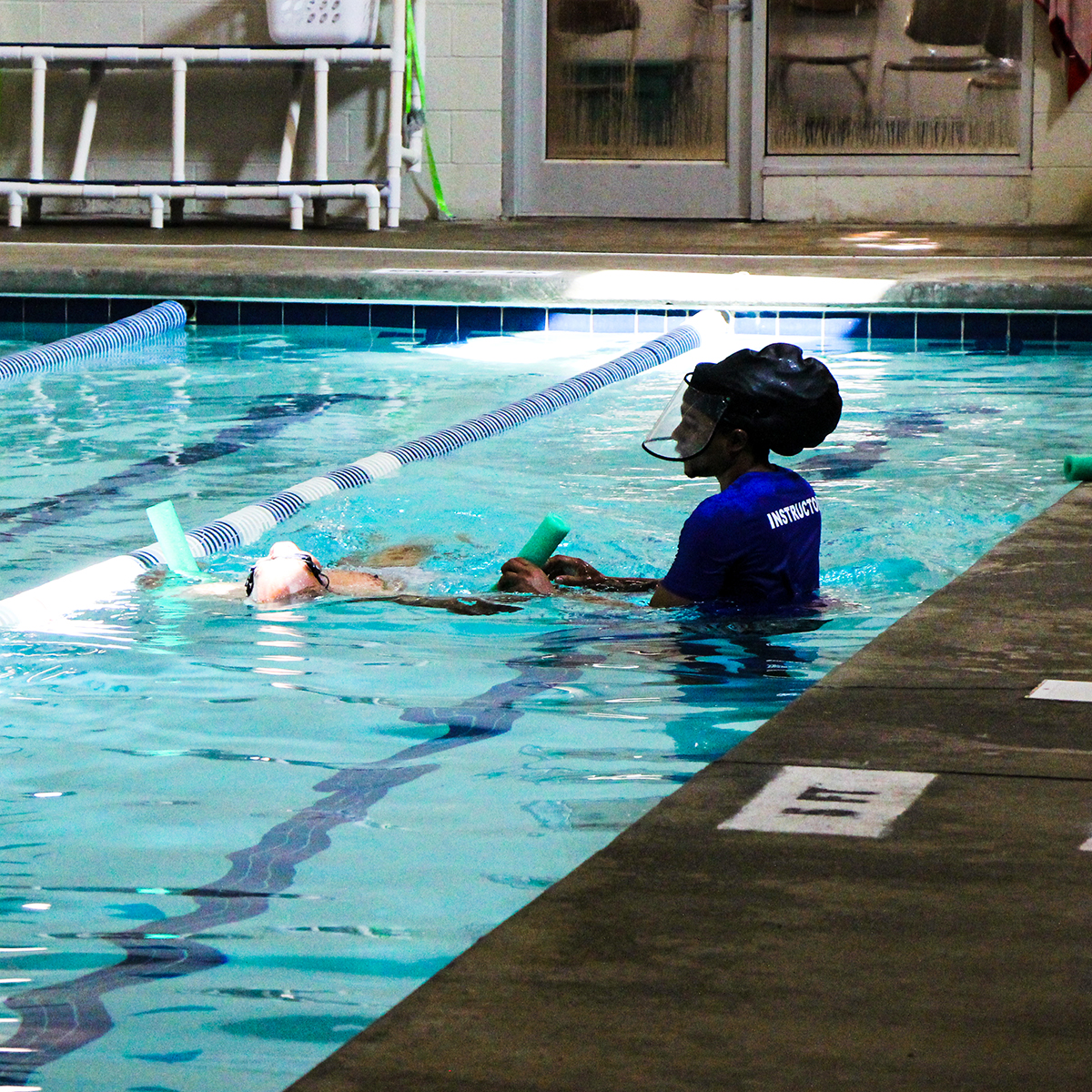 Student practicing back floating with instructor 